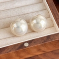 Detailed view of glossy cream-white round stud earrings on beige velvet jewelry box tray - Champagne (27859A)