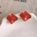 Macro detail of red enamel geometric square studs with golden edges on a white plate - Irregular Wavy Orange Style (27861C) / Orange
