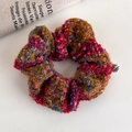 Detailed macro view of a red and blue tweed knitted scrunchie on a white surface - Colorful Tweed Knitted Style (24677)