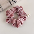 Detail of dusty pink velvet scrunchie showing rich texture and heart tag on beige background - Pink