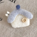 Close-up of handmade wool felt house brooch with wood button and blue pom-pom on linen - White House (27870A)