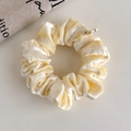 Primer plano de coletero de terciopelo amarillo claro con textura suave y pequeña etiqueta - Estilo Amarillo