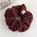 Detailed macro view of plush burgundy hair scrunchie with soft lamb wool texture and tag - Wine Red Plush Lamb Wool Style (26247A)