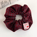 Close-up of red plaid scrunchie fabric with a sweet cherry woven label detail - Red Plaid Cherry Label Style (27837C)