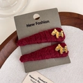 Detailed view of burgundy knit hair clips with golden horse motifs on display card - Two-Piece Set / Red