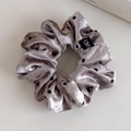 Detail view of silver velvet polka dot scrunchie with soft sheen and hand label - Gray Small