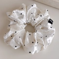 Macro detail of velvet polka dot scrunchie with handmade label and soft texture - White Large