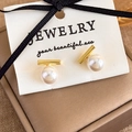 Detail view of minimalist pearl bar earrings with gold finish on jewelry display card - Gold