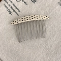 Detail of vintage polka dot acetate comb showing 10-tooth metal prongs on linen - Polka Dot Style / Beige