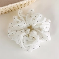 Détail d'un chouchou en tulle blanc à pois noirs avec une texture plissée et vaporeuse - Blanc