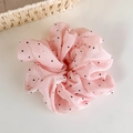 Gros plan sur chouchou en mousseline rose à pois avec texture nacrée délicate - Rose