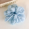 Détail du chouchou en organza bleu clair à pois avec texture de tissu froissé - Bleu