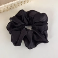 Gros plan d'un chouchou noir en mesh avec motifs à pois discrets et texture élégante - Noir