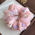 Detalle de coletero de organza rosa con rosas de tela 3D en una bandeja de madera - Naranja