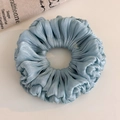 Detail of light blue pleated organza scrunchie with metallic luster and silky texture - Blue