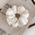 Dettaglio dell'elastico in raso color crema con pois rosa su sfondo di borsa di lino - Bianco A Pois Rosa
