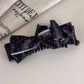 Dettaglio di un fermaglio per capelli in raso nero a pois con un fiocco raffinato - Grande / Nero