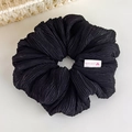 Detail of black pleated fabric hair tie with handmade label and vertical textures - Black