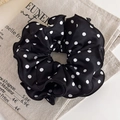 Détail d'un chouchou en satin noir à pois blancs posé sur un tissu en lin rustique - Noir à Pois Blancs