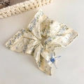 Détail d'un chouchou floral avec dentelle, nœud bleu et bouton vintage décoratif - Style Carré à Fleurs Bleues