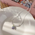 Detalle del collar de tulipa con perlas y cristal morado sobre bandeja de cerámica - Colgante de Tulipán Flor Azul (B 蓝色花朵)