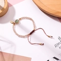 Detail eines rosa Perlenarmbandes mit grünem Rohsteinanhänger und gewebter Schnur - Grün (J7313)