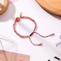 Detail eines rosa Kristallperlenarmbands mit verstellbarer roter Kordel und Goldanhänger - Dunkelrosa (J7312)