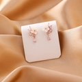 Detalle de los pendientes de flor en oro rosa con nácar blanco y cristales de circonita - Flor Gota de Agua (Dorado)