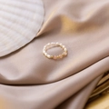 Close-up of handmade pearl ring with orange crystal beads on luxury silk fabric - Orange
