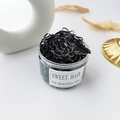 Detail of high elasticity black disposable hair ties in a minimalist cylindrical jar - Black