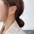 Dettaglio di un ear cuff dorato con zirconi brillanti indossato da una modella elegante - Stile Strass a Una Fila (15065)