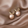 Detail of luxury champagne pearl earrings on elegant silk fabric background - Pink