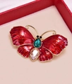 Detail van vintage emaille vlinderbroche met smaragd en champagne edelstenen - Rood