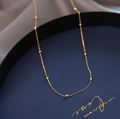 Elegant gold satellite chain necklace with delicate beads on blue display tray - Minimalist Chain Necklace