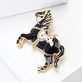 Close-up of a black enamel horse brooch with gold trim and inlaid sparkling white rhinestones - Black