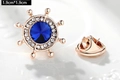 Macro view of 1.9cm rose gold rudder brooch with blue center stone and white rhinestones - Ship Helm (X0234) / 1.9cm x 1.9cm / Blue