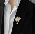 Elegante vlinderbroche met roze vleugels en parel op een zwart colbertjasje - Roze Paars
