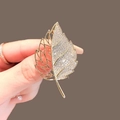 Exquisite gold leaf brooch with micro-paved cubic zirconia and hollow line design - Gold