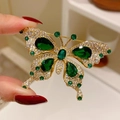 Eleganter Smaragd-Schmetterlings-Brosche in Gold mit funkelnden weißen Zirkonia-Akzenten - Vintage Smaragd Schmetterling Stil