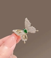 Dettaglio di una spilla a farfalla con diamanti bianchi e gemma verde marquise - Verde