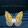 Elegant gold butterfly brooch with yellow marquise zircons and a white pearl accent - Butterfly Style