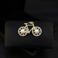 Vue détaillée d'une broche vélo en métal doré avec perles blanches et zircons brillants - Vélo Doré (X1440)