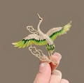 Eleganter Kranich-Anstecker mit grünen Emaille-Flügeln und weißen Strasssteinen - Kranich und Wolke Stil