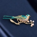 Vintage magpie brooch with green enamel and pearls on gold branch over blue silk - Green Gold Magpie Style