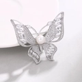 Lujoso broche de mariposa con perla blanca y circonitas brillantes en metal plateado - Blanco