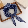 Detailopname van een donkerblauwe zijden paisley sjaal elegant gepresenteerd in een houten dienblad - Blauw