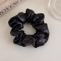 Close-up of black PU leather scrunchie with soft pleats and elegant glossy texture - Black Small
