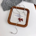 Macro shot of silver snake chain with red pony pendant and gold star on a tray - Red (27608A)
