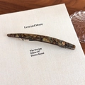 Close-up of marble acetate hair clip with golden logo on a minimalist background - Green Multi-color (27606E)