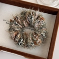 Detailed close-up of colorful fuzzy knit scrunchies in a velvet display tray - Green Pink Mixed